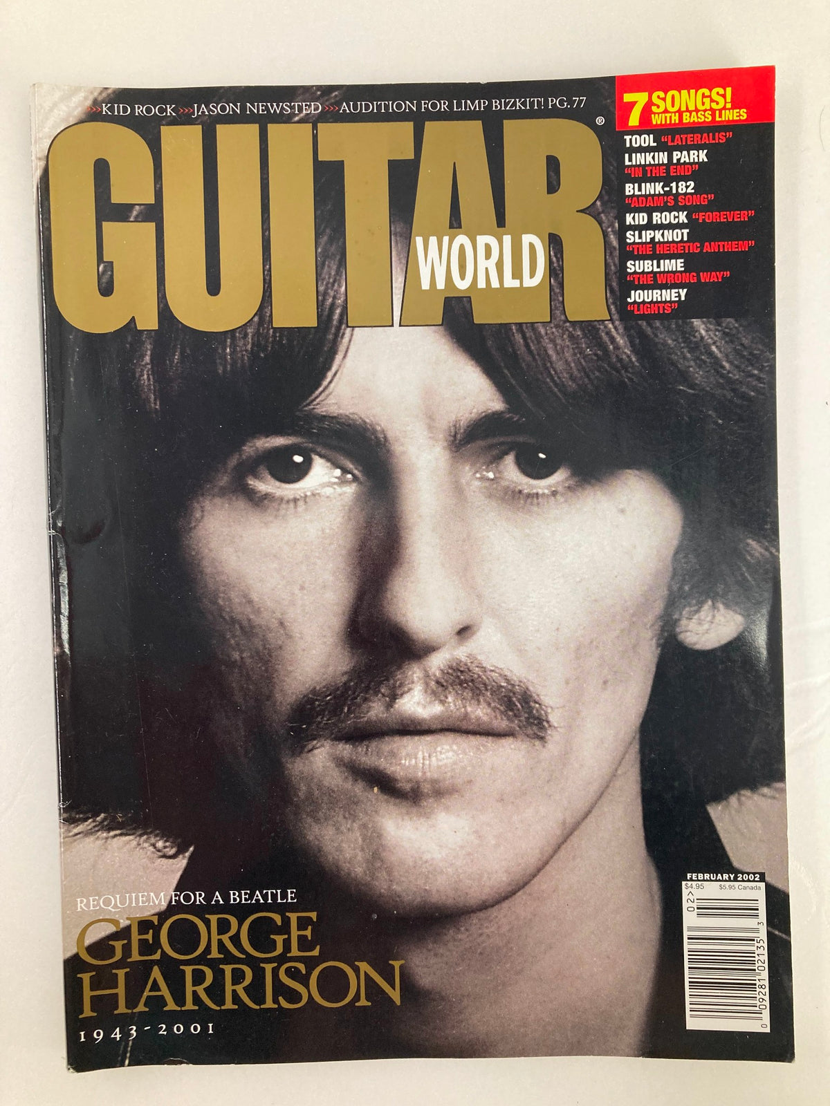 Guitar World Magazine February 2002 featuring George Harrison, with a tribute titled 'Requiem for a Beatle.' The cover showcases a close-up of George Harrison's portrait, emphasizing his iconic moustache and features. This magazine celebrates the legacy of the legendary musician who passed away in 2001.