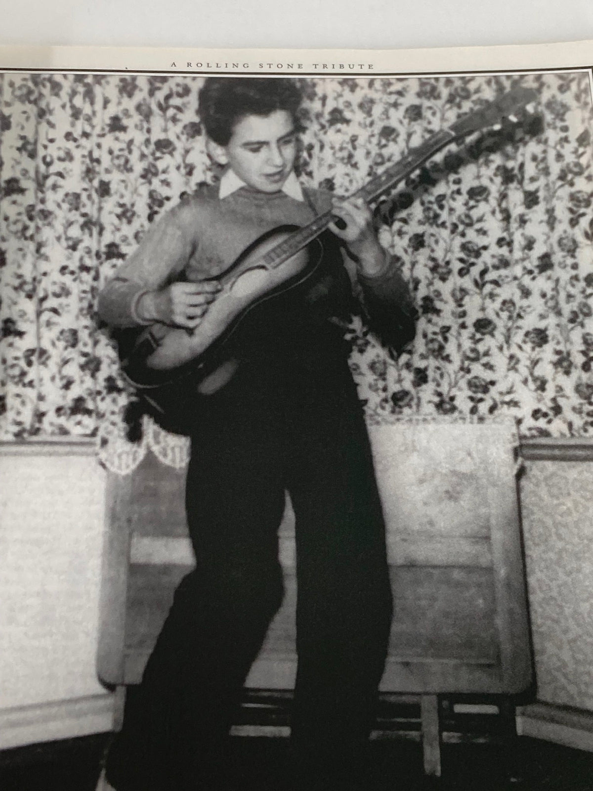 Vintage photograph of George Harrison as a young boy, featured in the Rolling Stone Magazine Special Edition 2001, showcasing his early passion for music.
