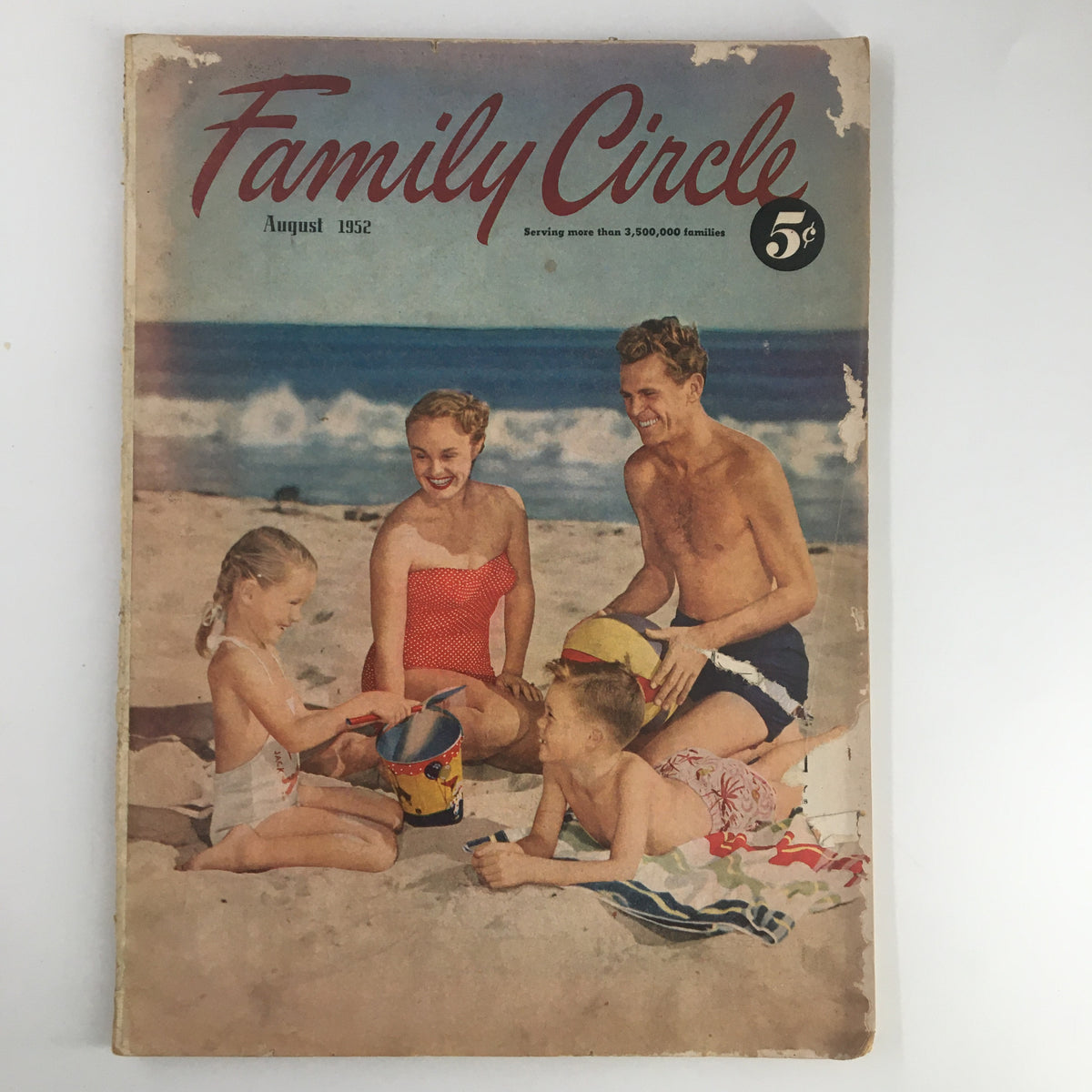 Vintage Family Circle Magazine August 1952 cover showcasing a family at the beach, featuring a mother, father, and two children enjoying summer activities.