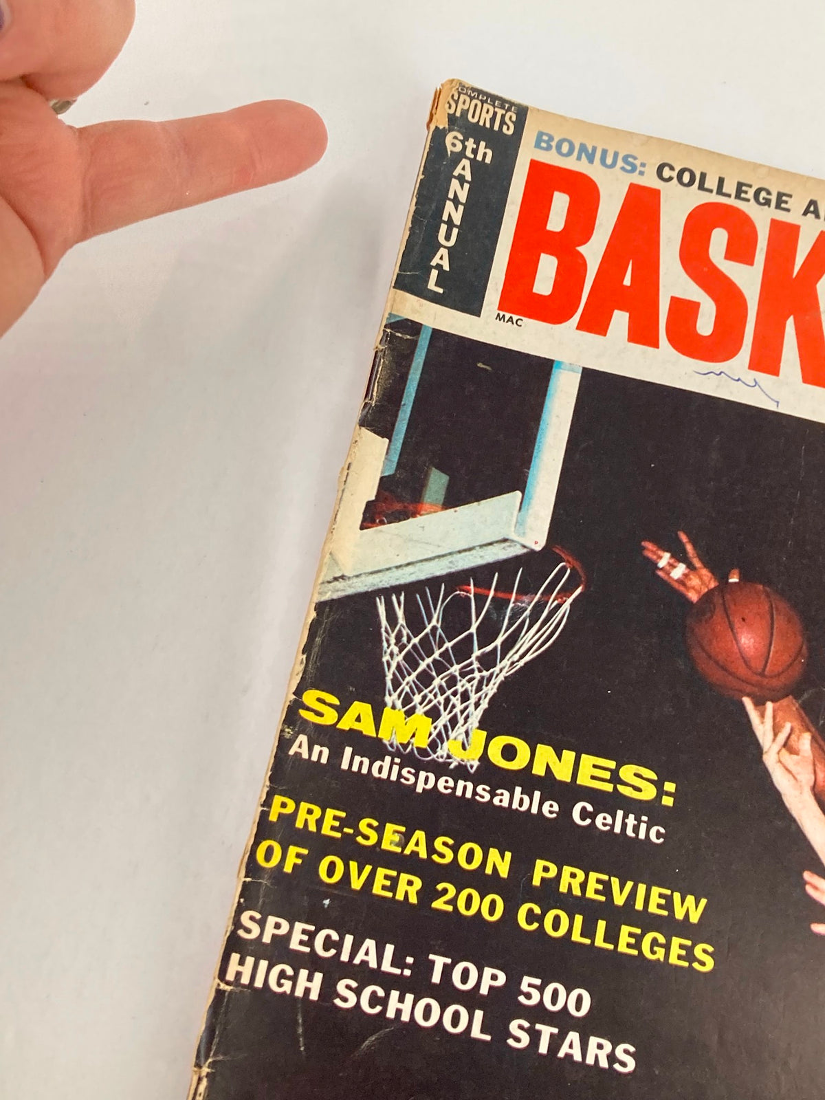 Close-up of 1965 VTG Sports Basketball Magazine featuring Jerry West and Sam Jones, highlighting article titles and magazine details.