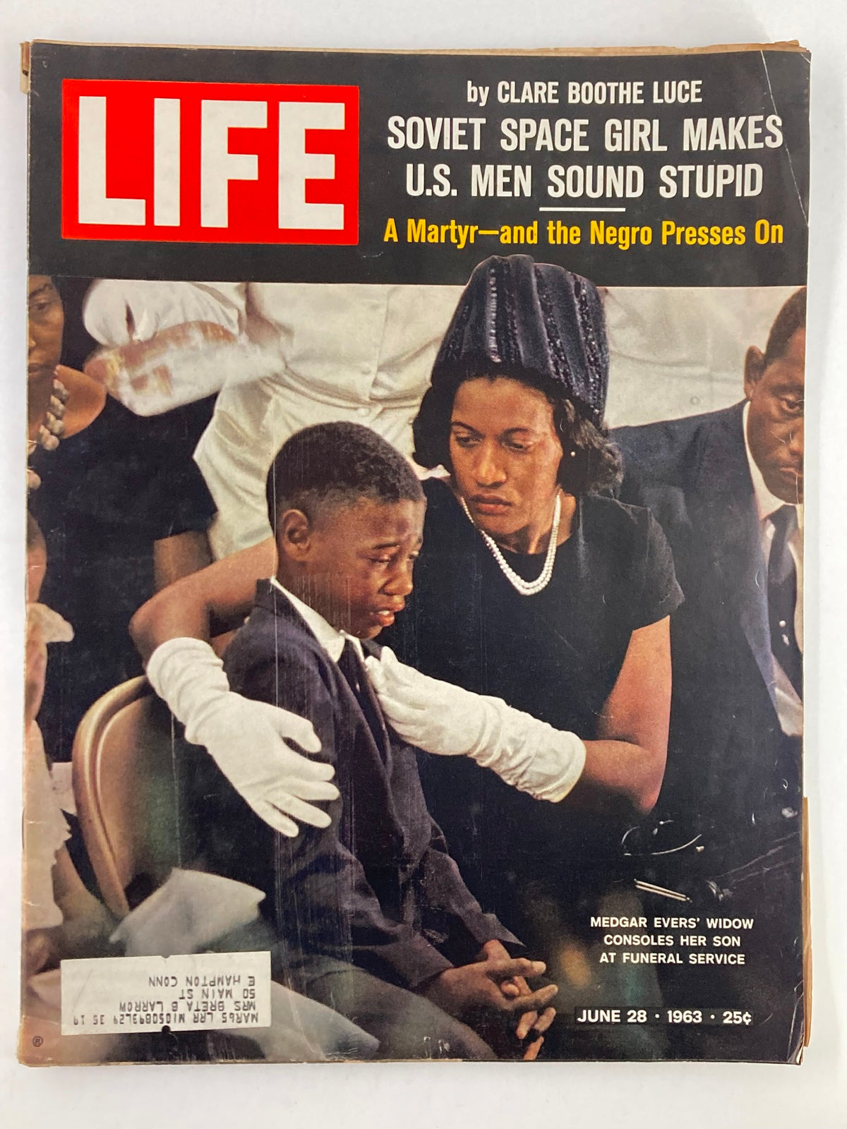 Cover of the June 28, 1963 issue of Life Magazine titled 'A Martyr - and the Negro Presses On', featuring a poignant scene of Medgar Evers' widow comforting her son at his funeral service. This vintage magazine reflects significant moments in American history and the civil rights movement.