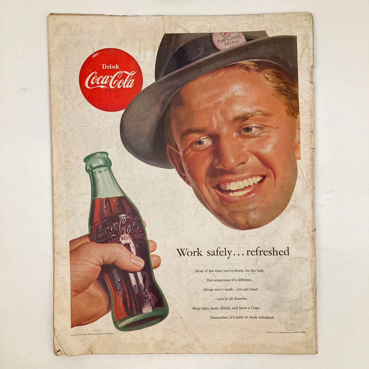 Vintage Coca-Cola advertisement featuring a cheerful man wearing a hat, holding a bottle of Coca-Cola, promoting the message 'Work safely... refreshed.' from the Saturday Evening Post Magazine December 26 1953 Christmas - Schaeffer No Label.