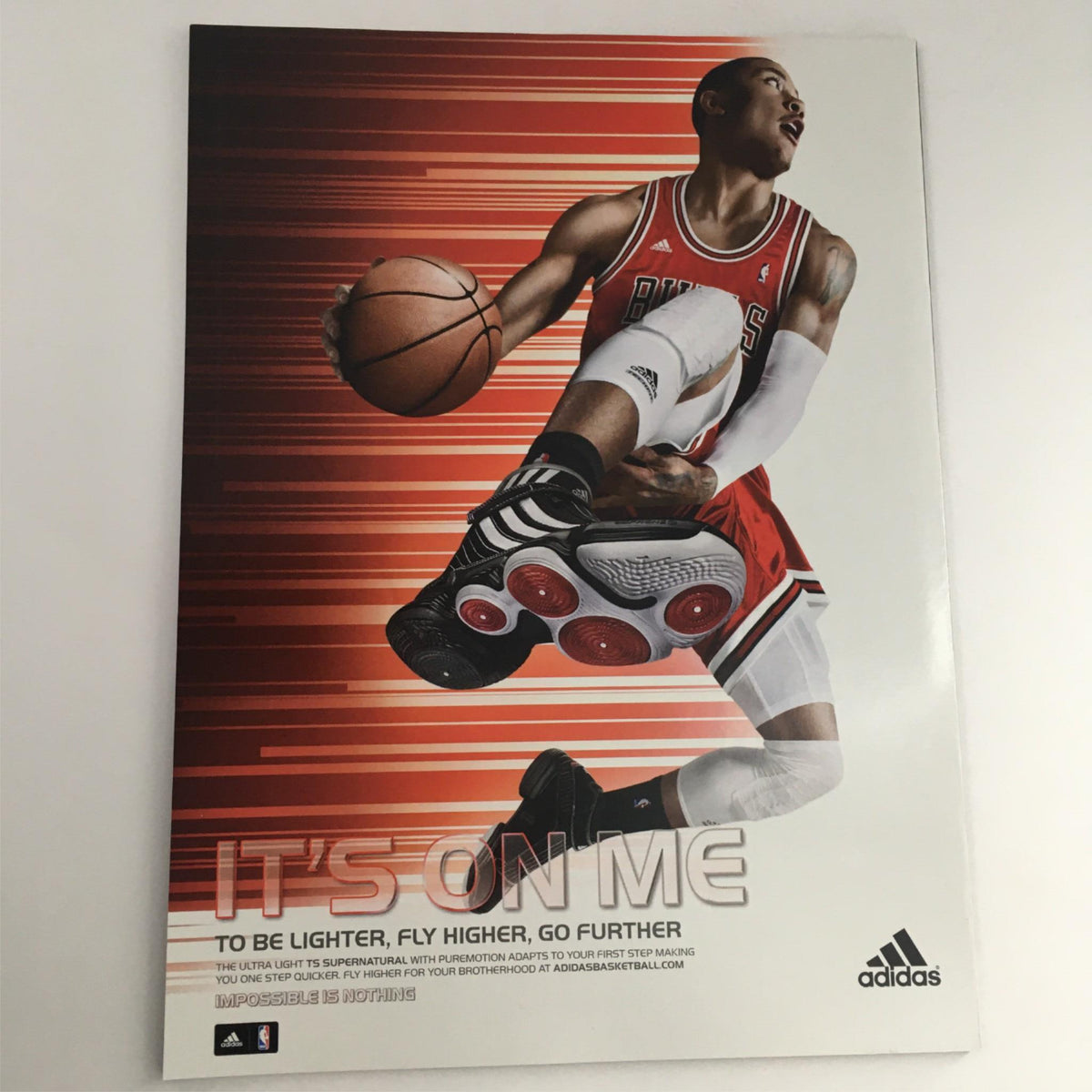 Adidas basketball advertisement featuring a player in mid-air action, promoting the message 'It's On Me'. This image captures the energy of basketball culture, complementing the 2010 Dime Magazine August-September 2010 LeBron James Miami Heat No Label NM.