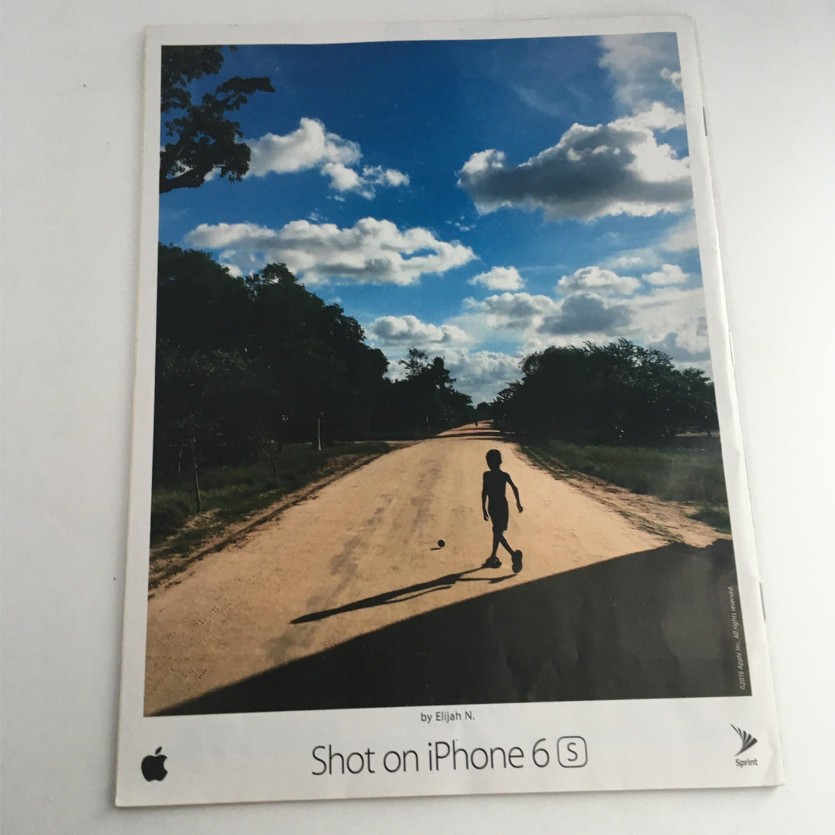 The back cover of Sports Illustrated Magazine June 27, 2016, showcasing a scenic photograph of a child walking on a dirt road under a beautiful sky, promoting the Apple iPhone 6S.