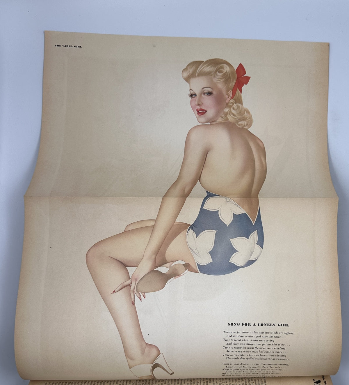 Foldout page from Esquire Magazine July 1944 showcasing a pinup illustration titled 'Song for a Lonely Girl' depicting a glamorous blonde woman in a stylish swimsuit.