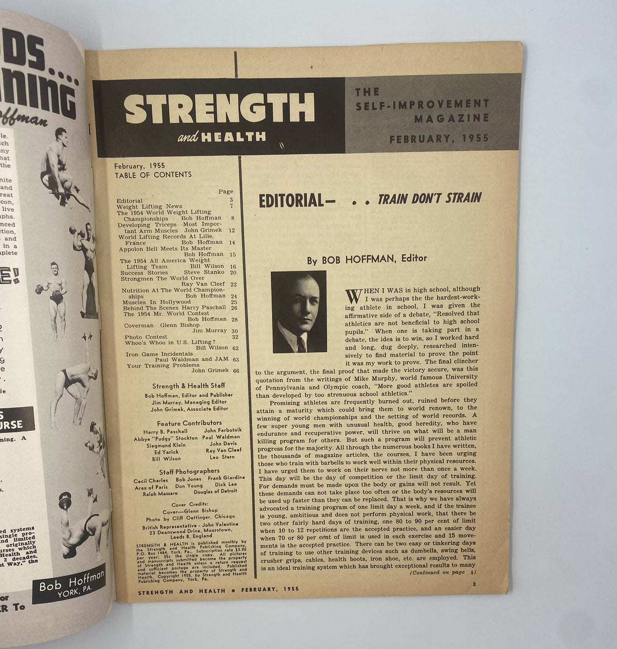 Editorial page of Strength and Health Magazine February 1955 with the title 'Editorial - Train Don't Strain' by Bob Hoffman, discussing weightlifting insights and fitness.