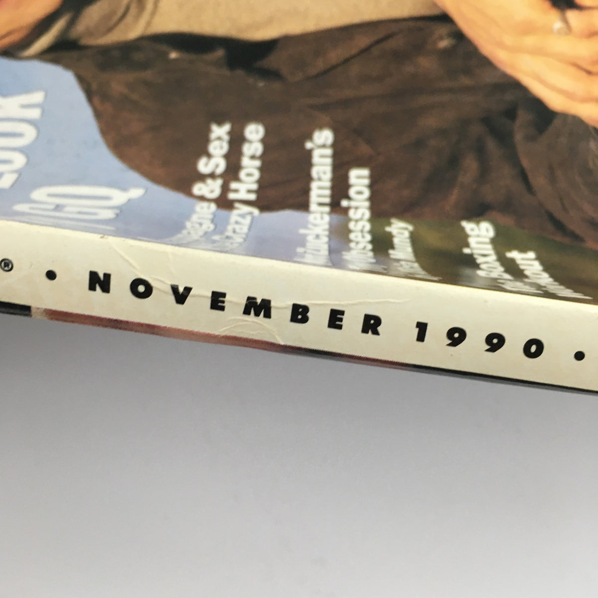 Close-up of the spine of GQ Magazine November 1990, clearly displaying the publication date. This vintage magazine issue includes features on fashion and celebrity insights, particularly focusing on Jeremy Irons.