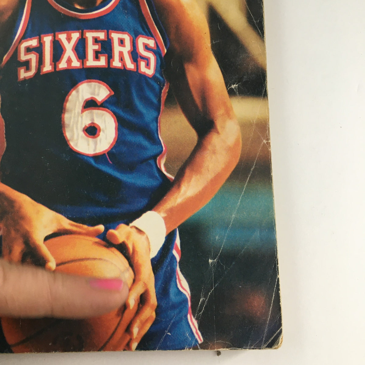 Detailed view of Street & Smith's Official College, Pro & Prep Yearbook 1977-1978 showing basketball player in Sixers jersey holding a basketball, highlighting the magazine's features and title.