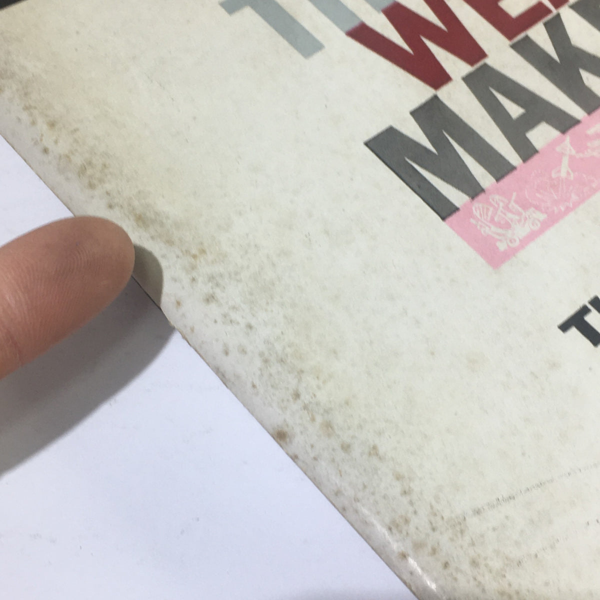 Close-up of the cover of Business Week Magazine showing a stained edge and finger pointing at the text 'The Weapon Makers' dated October 10, 1959.