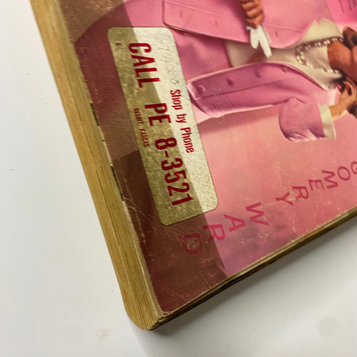 Close-up of the 1964 Montgomery Ward Spring and Summer Catalog cover highlighting the contact information sticker and detail of the pink suit worn by the model.