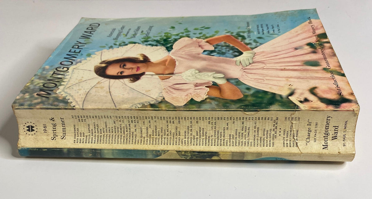 Side view of the 1961 Montgomery Ward Spring and Summer Catalog, depicting the vintage cover with a young model in a pink dress.