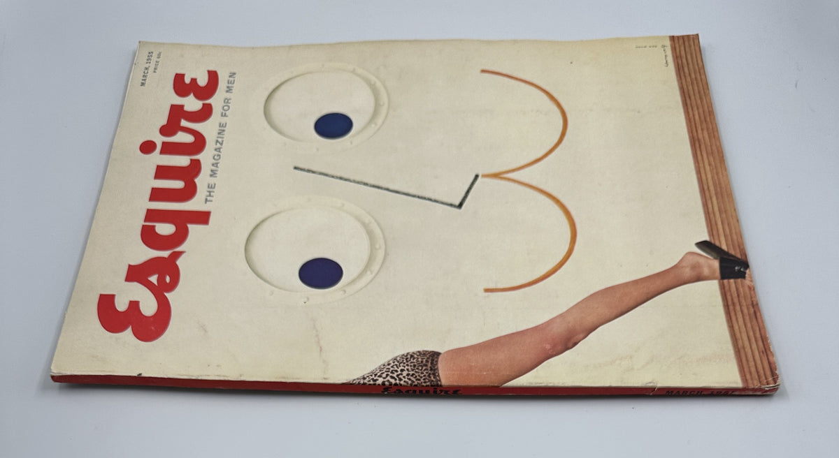 Esquire Magazine March 1955 cover displayed at an angle, highlighting the iconic artwork of a smiling face formed by graphic elements alongside a leg in a leopard print bikini.