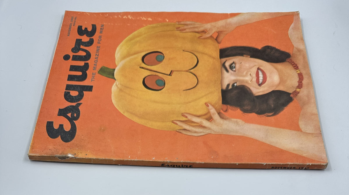 Side view of Esquire Magazine November 1955 featuring a woman holding a pumpkin on her head, emphasizing the vintage design and aesthetic of the magazine.
