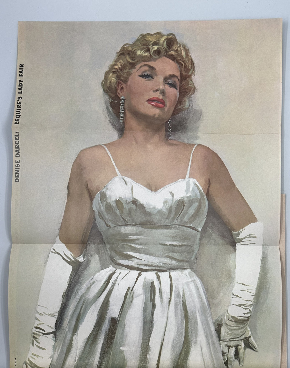 Esquire Magazine April 1956 features a foldout of Denise Darcel, an elegant illustration showcasing her in a glamorous white gown with gloves, highlighting the vintage charm of the era.