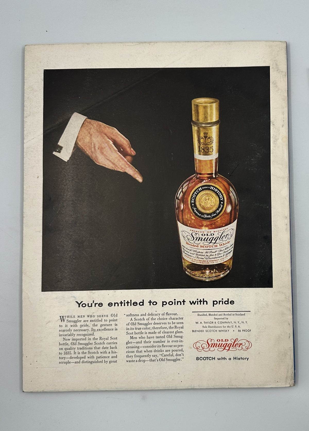 Esquire Magazine April 1956 includes a classy advertisement for Smuggler's Scotch, featuring a hand pointing to the bottle, emphasizing luxury and fine spirits.