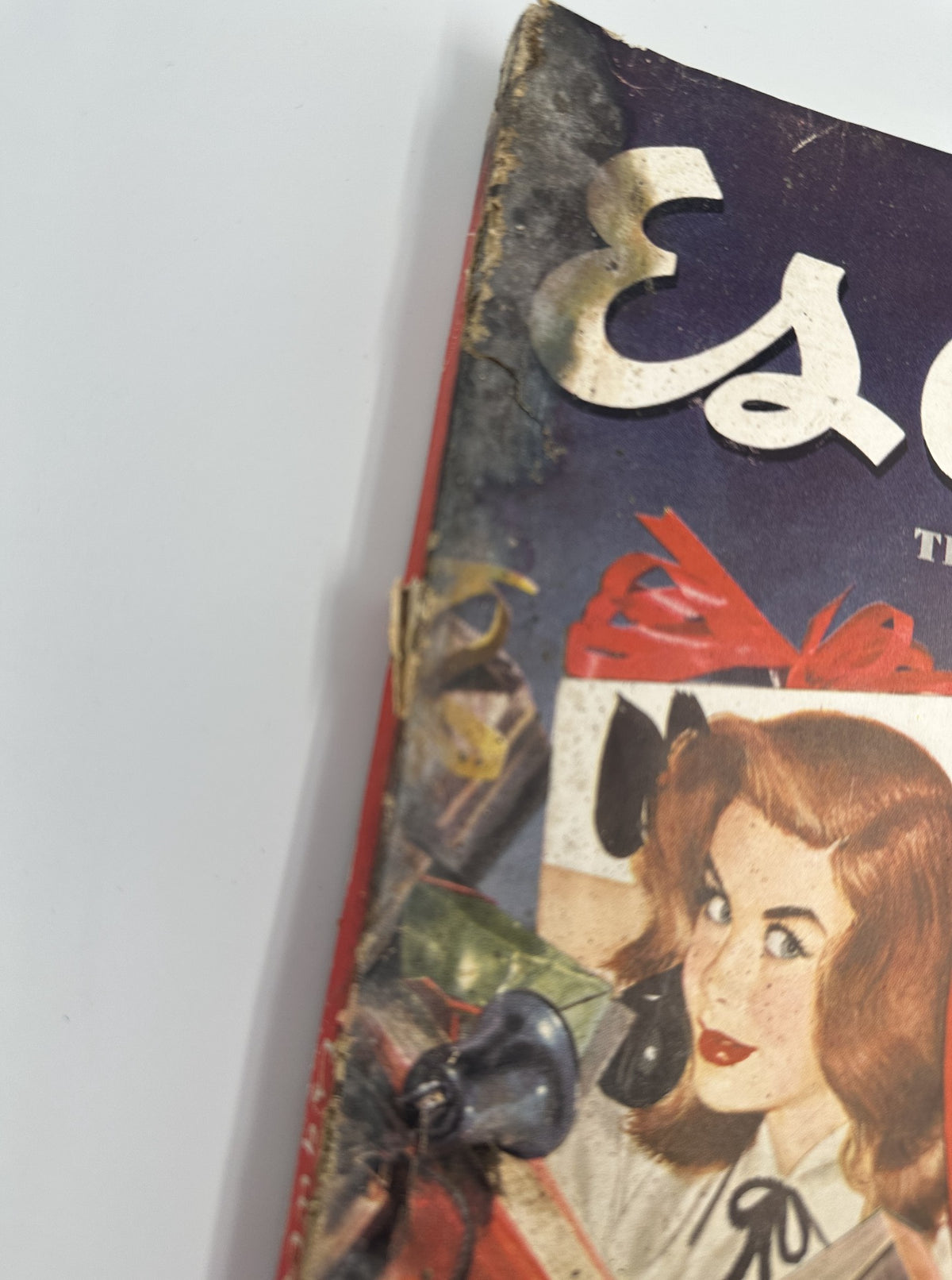 Close-up of the top corner of Esquire Magazine December 1950, focusing on the vibrant cover art featuring a woman with holiday decorations.