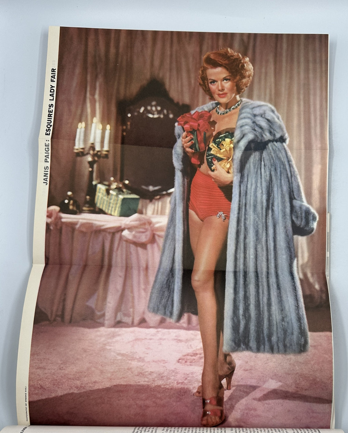 A fashion spread from December 1954 Esquire Magazine featuring actress Janis Paige in a glamorous setting, showcasing vintage swimwear and holiday style.