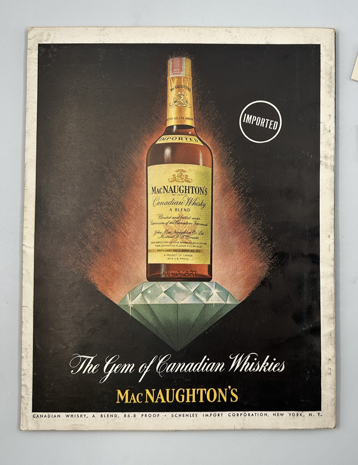 Esquire Magazine November 1954 includes an advertisement for MacNaughton's Canadian Whisky, featuring a sleek bottle design against a luxurious background.