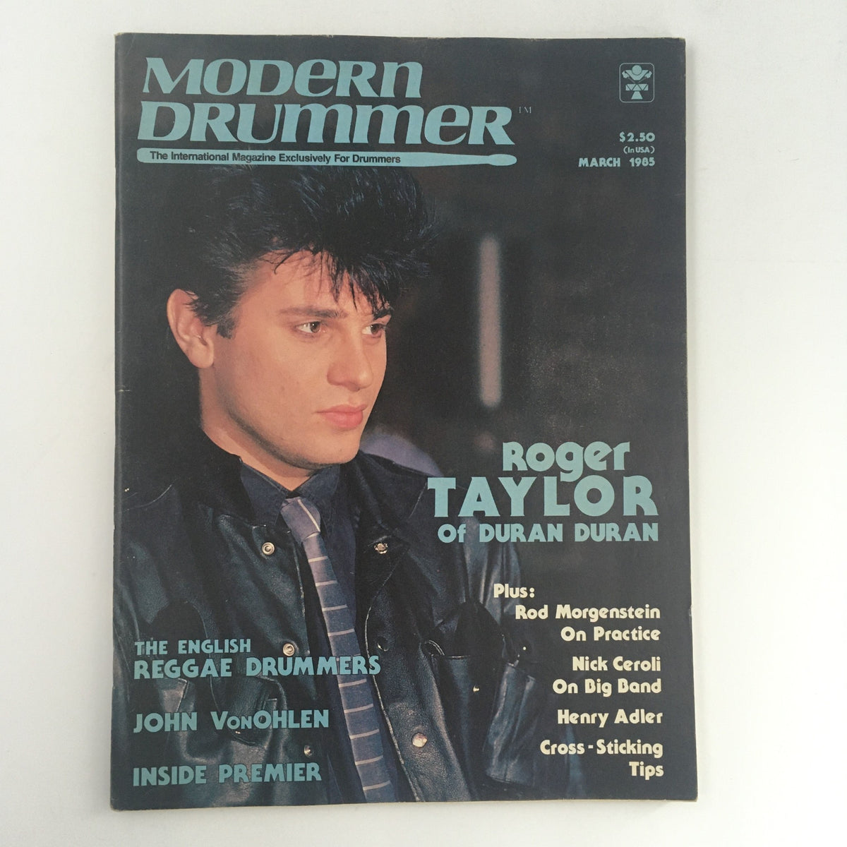 Modern Drummer Magazine March 1985 cover featuring Roger Taylor of Duran Duran. The cover showcases a close-up of a young Roger Taylor in a stylish leather jacket, highlighting his iconic hairstyle from the 1980s. The magazine includes features on drummers John VonOhlen and Nick Ceroli, making it a collectible item for vintage magazine and music enthusiasts.