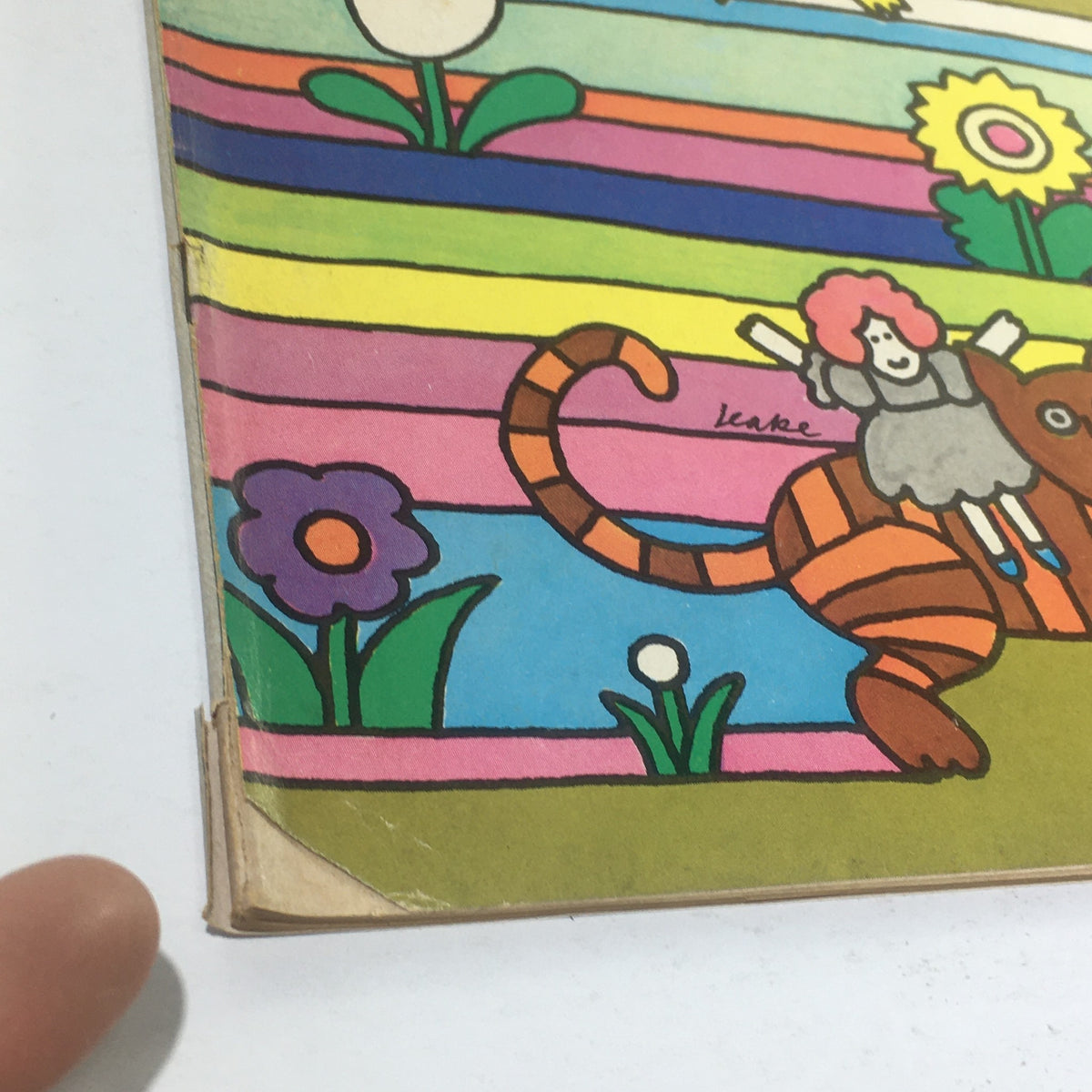 Close-up view of Cue Magazine, July 11, 1970 - Detail of the vibrant cover design including flowers and a stylized cartoon tiger with a child character, by artist Don Leake.