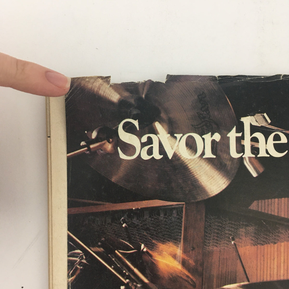 Detailed view of the back cover of Modern Drummer Magazine May 1982, highlighting the phrase 'Savor the' above a visual of a cymbal, indicating a focus on drumming techniques.
