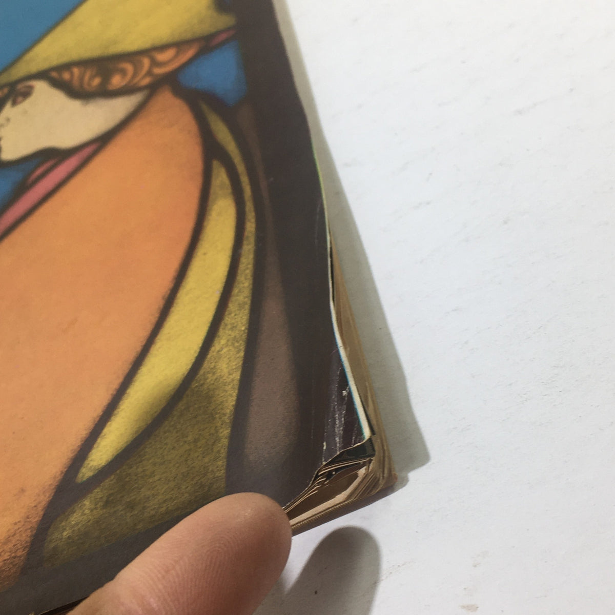 Close-up detail of the edge of Cue Magazine from December 13, 1969, highlighting minor wear and imperfections on the cover, indicating its vintage nature and history associated with 'Amhahl & The Night Visitors.'