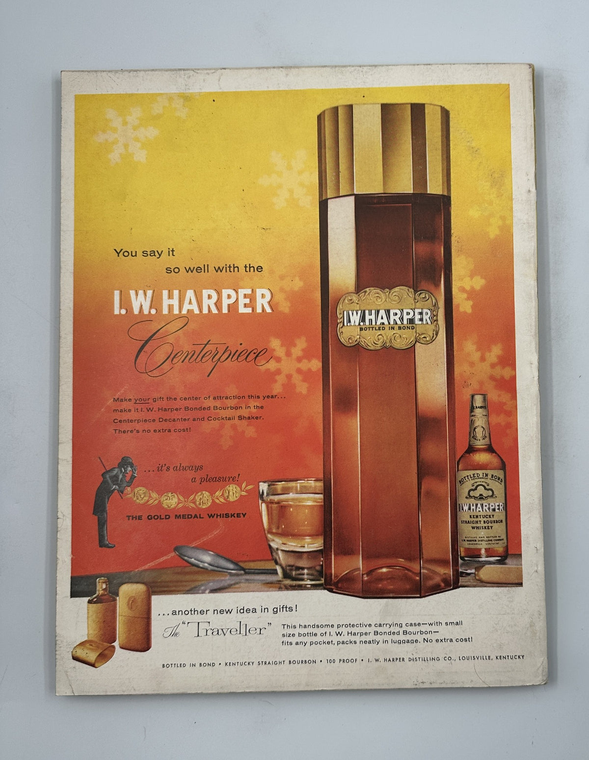 Esquire Magazine December 1956 displaying an advertisement for I.W. Harper whiskey featuring an elegant bottle design against a festive backdrop. The ad promotes the whiskey as a perfect centerpiece for holiday gatherings.