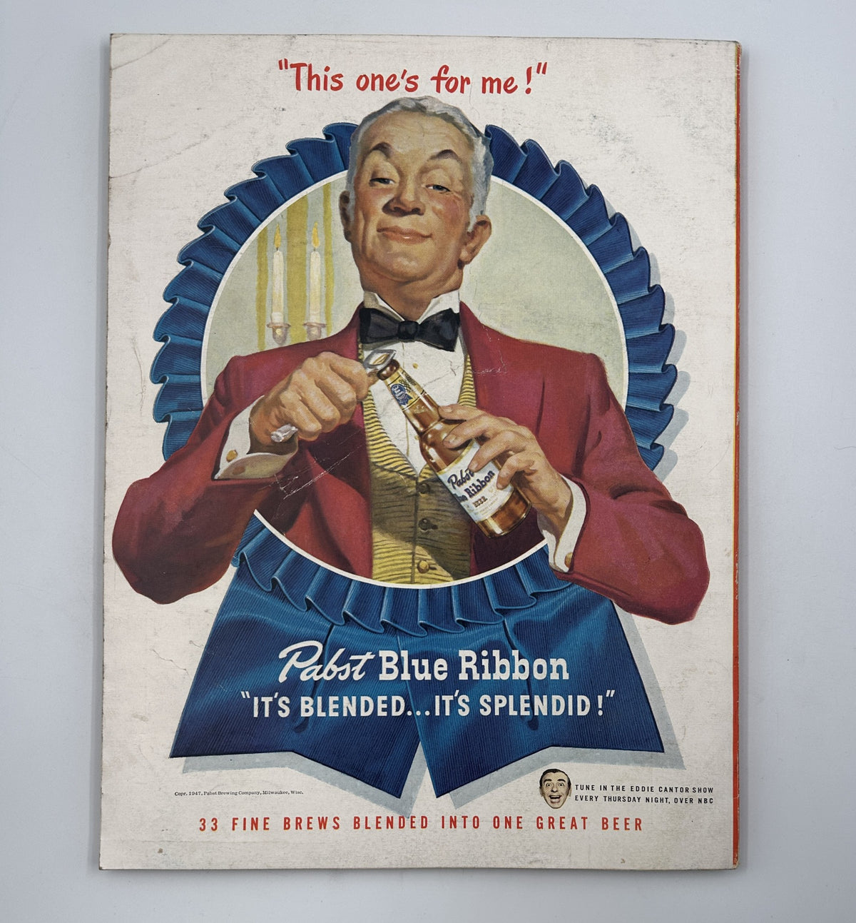 Esquire Magazine July 1947 cover featuring a jovial man in a red jacket opening a bottle of Pabst Blue Ribbon beer, promoting the beverage with the tagline 'It's blended...it's splendid!'