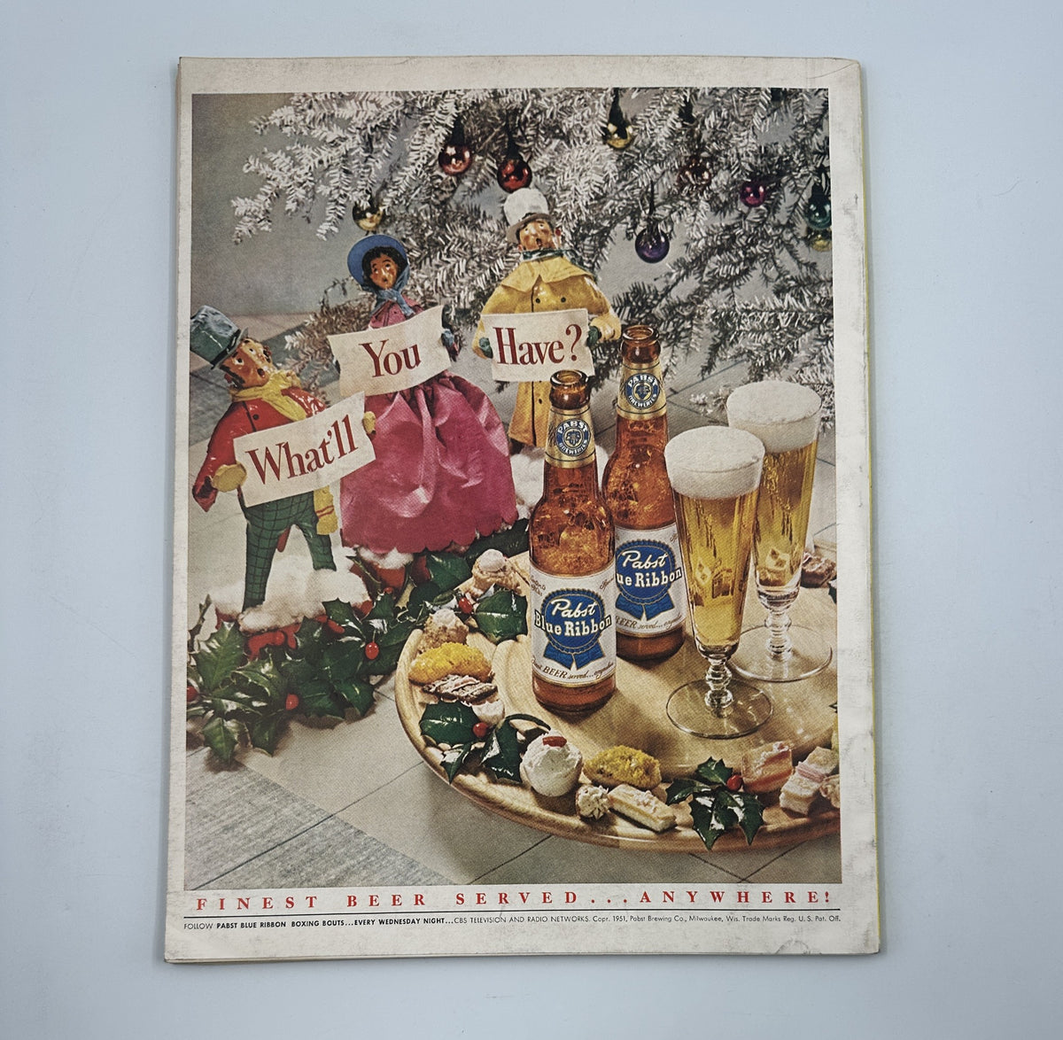 Cover of Esquire Magazine January 1952 featuring holiday-themed illustrations with bottles of Pabst Blue Ribbon beer, decorative pine branches, and figurines, highlighting the slogan 'Finest Beer Served... Anywhere!'