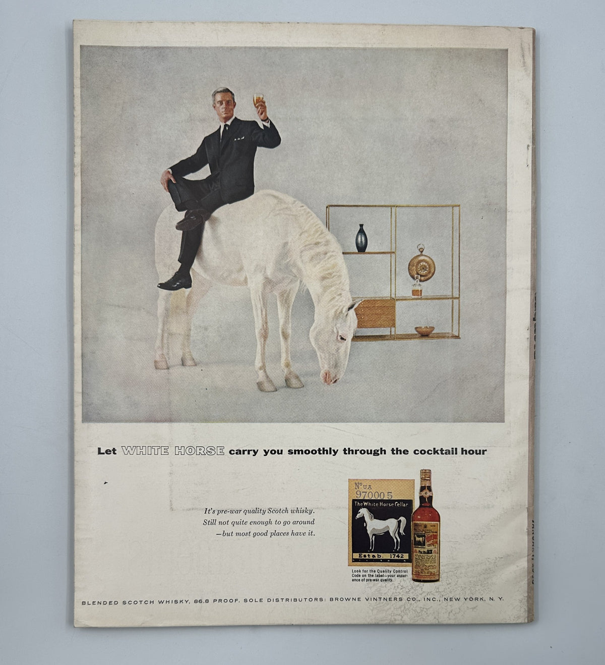 Esquire Magazine January 1956 featuring an advertisement for White Horse Blended Scotch Whisky, showcasing a man elegantly dressed on a white horse, promoting the beverage for the cocktail hour.