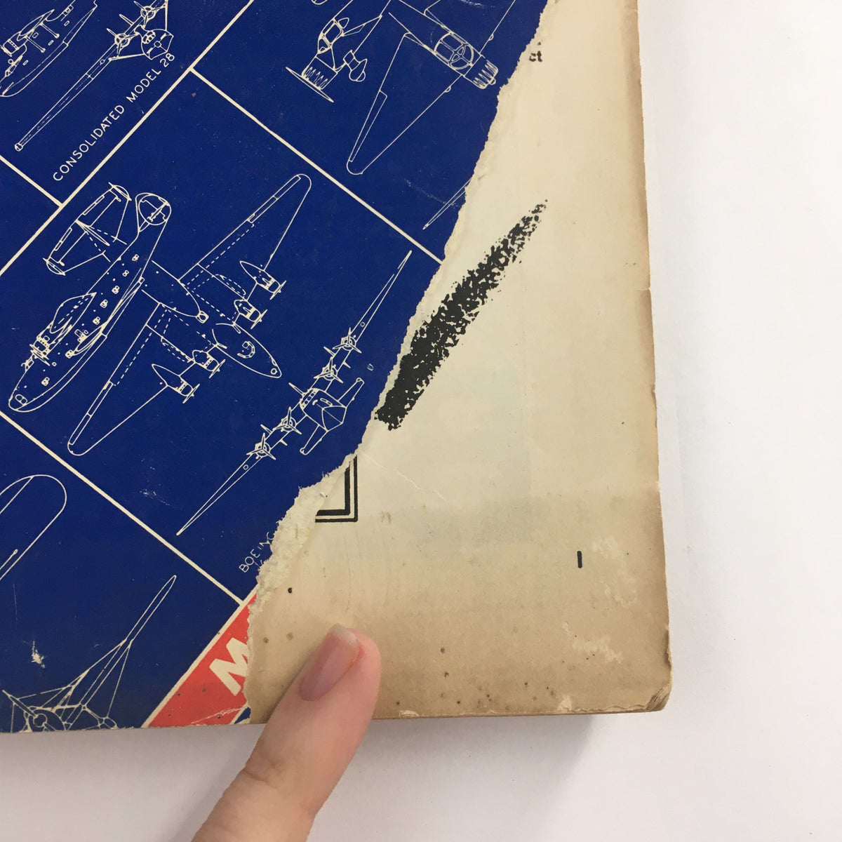 Detailed view of the torn cover of Aero Digest Magazine March 1939, highlighting the aircraft illustrations and corner wear, emphasizing its vintage authenticity.