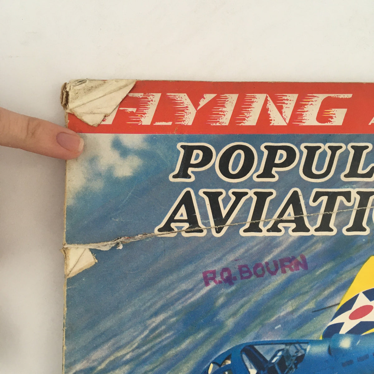Detail view of the spine and top corner damage of Flying & Popular Aviation Magazine Vol 27 #5 from November 1940, showcasing wear consistent with age.