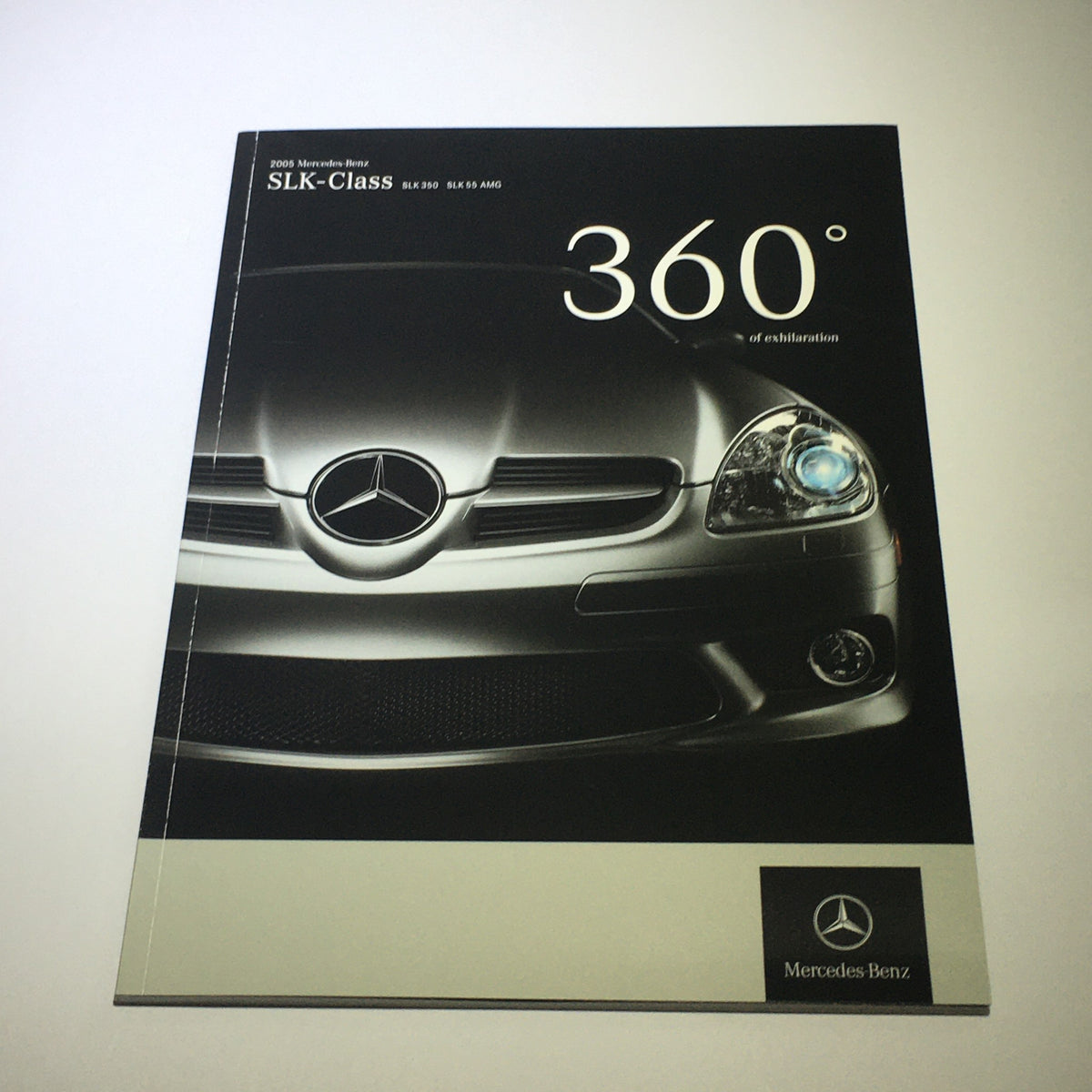 Cover of the 2005 Mercedes-Benz SLK-Class 350 55 AMG Dealership Car Auto Brochure Catalog featuring sleek car design.
