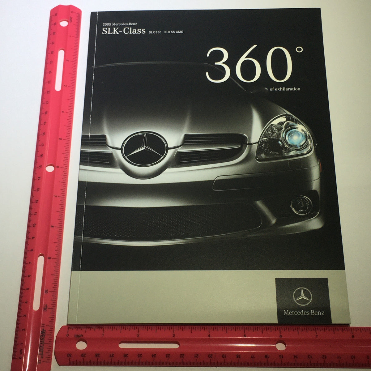 2005 Mercedes-Benz SLK-Class 350 55 AMG brochure displayed with a ruler for size reference.