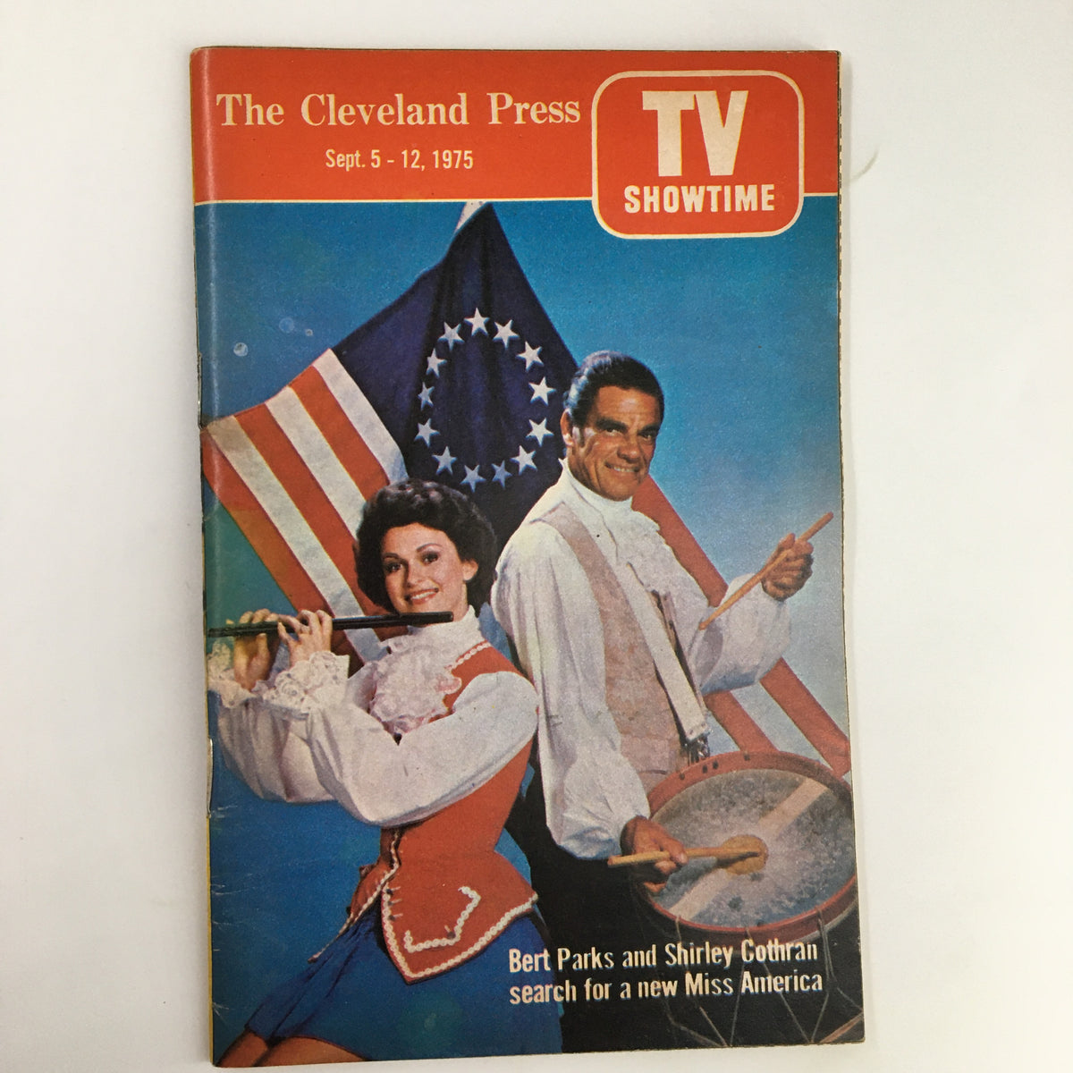 Cover of The Cleveland Press TV Showtime Guide for September 1975 featuring Bert Parks and Shirley Cothran, with a patriotic background of flags, highlighting the search for a new Miss America.