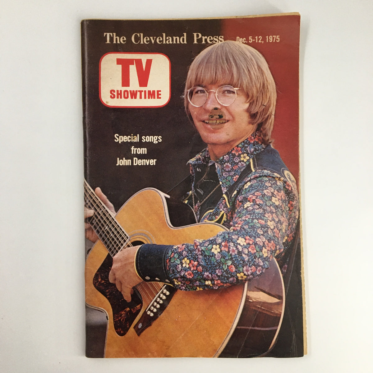 Cover of The Cleveland Press TV Showtime Guide December 5 1975 featuring John Denver, showcasing his special songs, with a floral patterned shirt and an acoustic guitar.