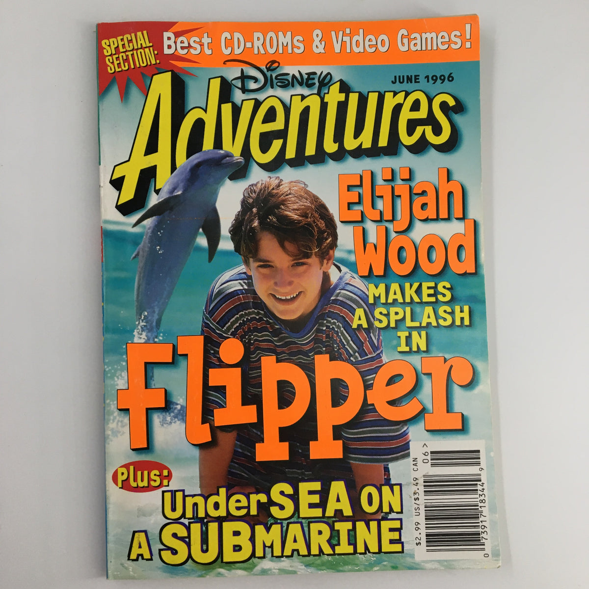 Disney Adventures Magazine cover from June 1996 featuring Elijah Wood making a splash in Flipper, along with a dolphin illustration and promotional text for best CD-ROMs and video games.