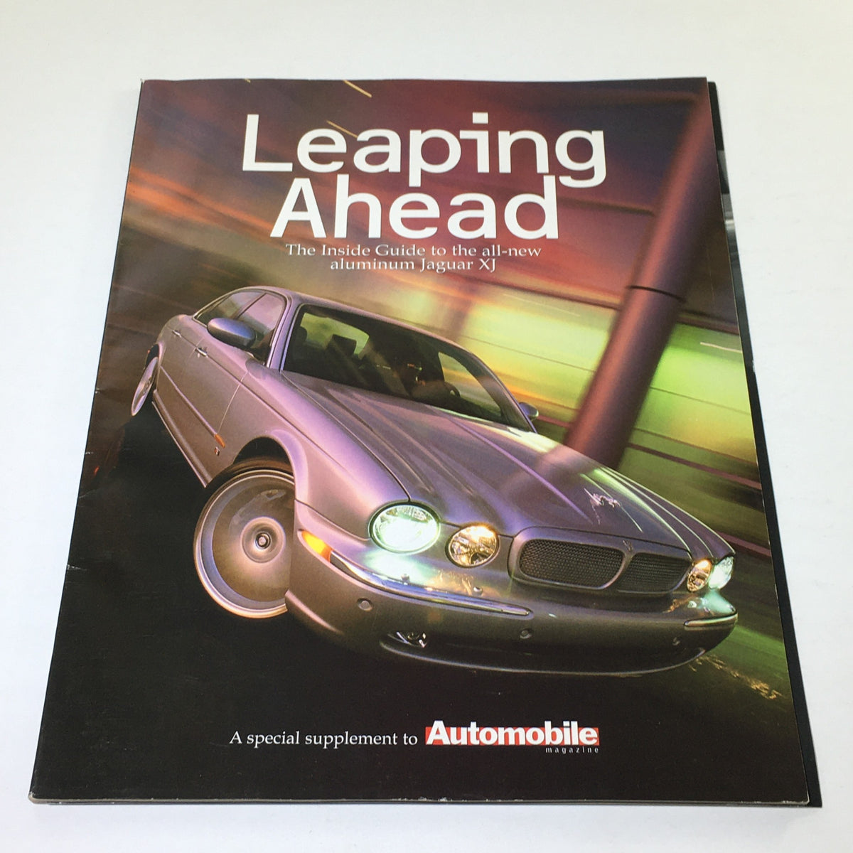 2000 Jaguar Automobile Magazine Dealership Car Auto Brochure Catalog featuring the cover titled 'Leaping Ahead' with a Jaguar XJ under dynamic lighting.
