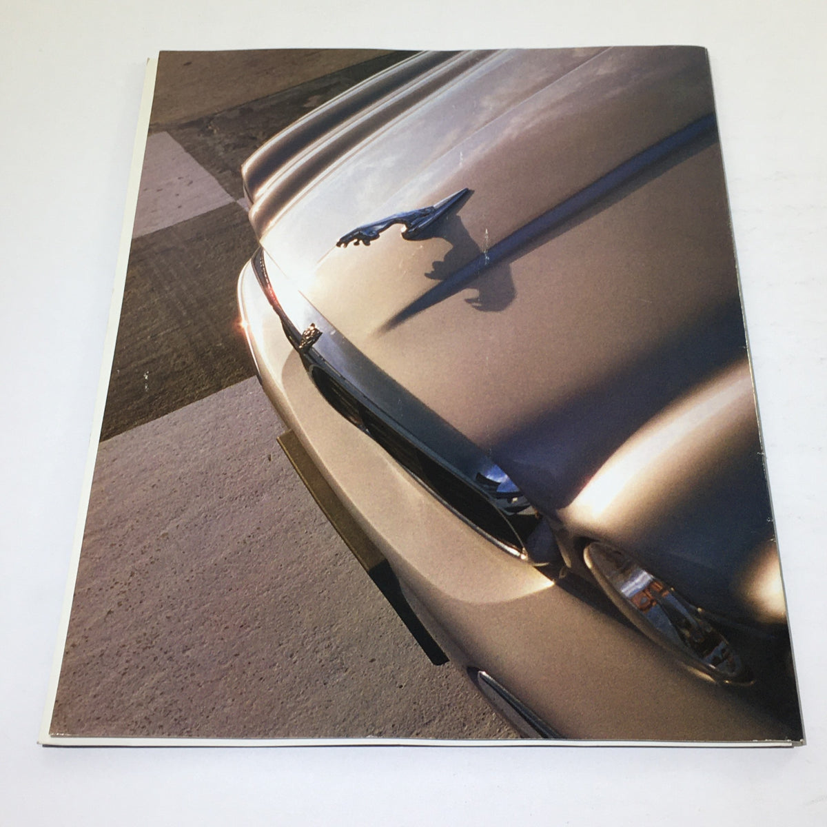 Back cover of the 2000 Jaguar Automobile Magazine Dealership Car Auto Brochure Catalog showcasing the distinctive Jaguar hood ornament in natural light.