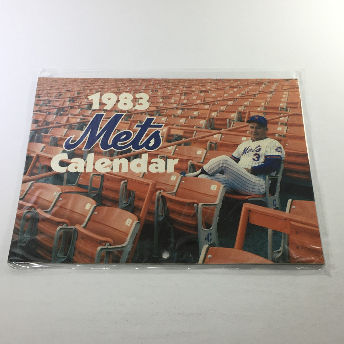 Vintage 1983 New York Mets Calendar featuring a nostalgic design with orange stadium seats and a player in Mets uniform, perfect for collectors and fans of vintage memorabilia.