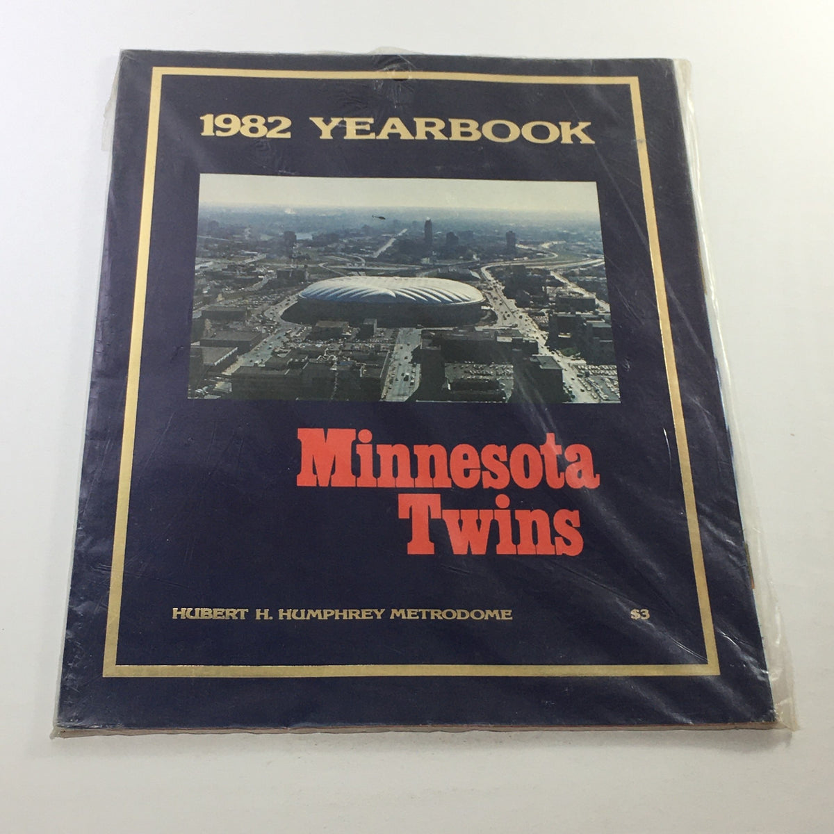 1982 Minnesota Twins Yearbook featuring the Hubert H. Humphrey Metrodome on the cover, showcasing the iconic stadium associated with the team's first year at this venue.