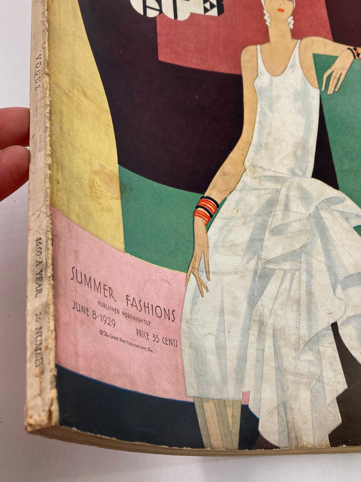 Detailed view of the VTG Vogue Magazine June 8 1929 cover showcasing the title and date with a colorful background, highlighting summer fashions.