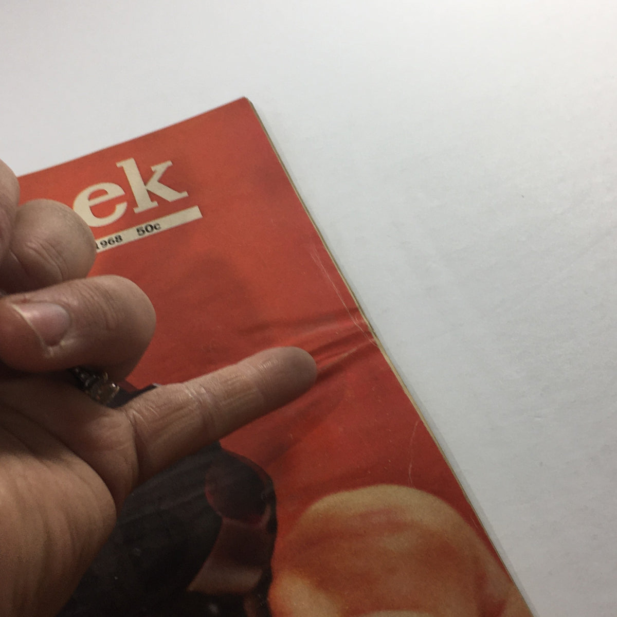Close-up view of the Newsweek Magazine cover from June 24, 1968, titled 'A Question Of Guns,' highlighting the magazine's condition with fingers pointing to a crease.