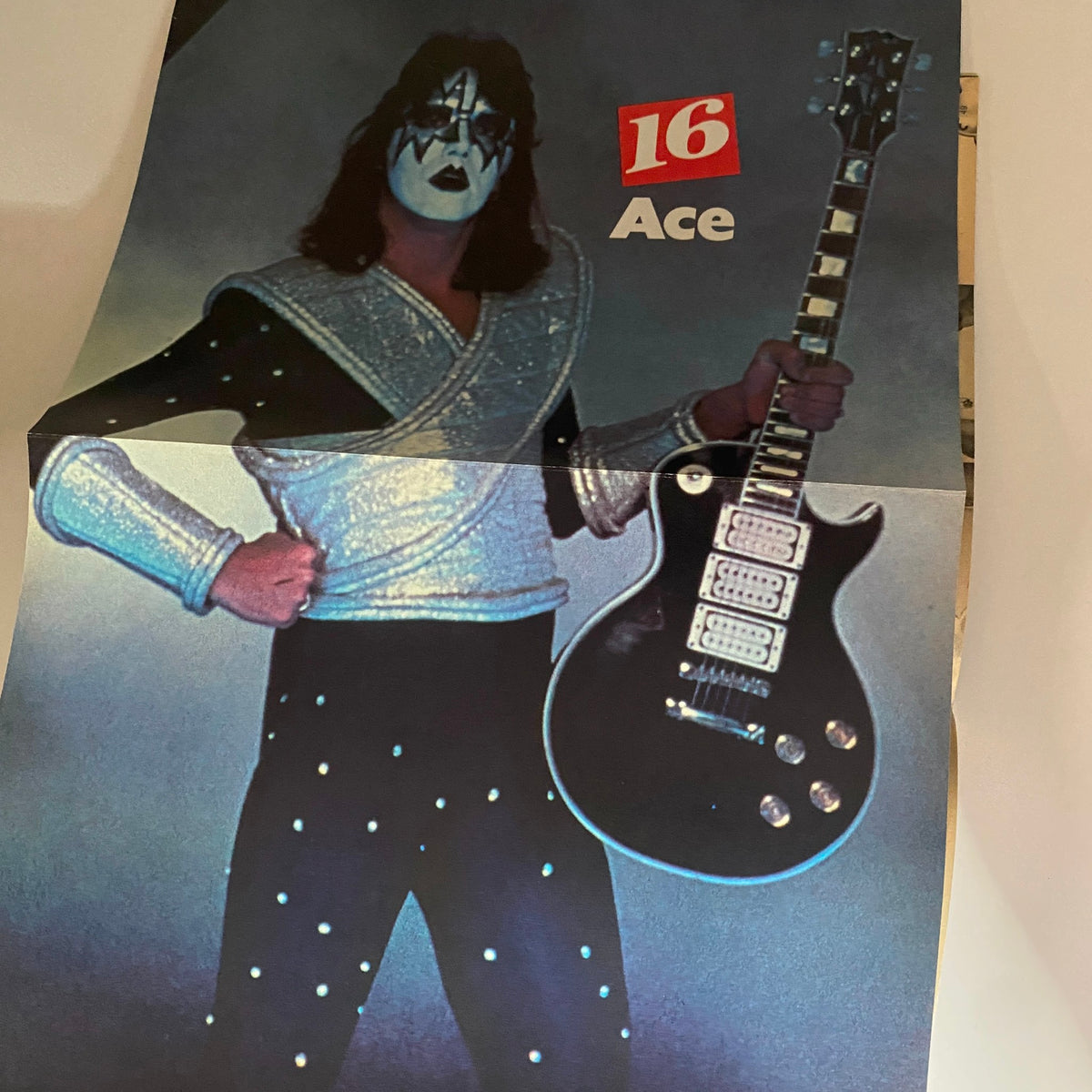 16 Magazine September 1979 poster of Ace Frehley from KISS showcasing glam rock style with a striking outfit and electric guitar.