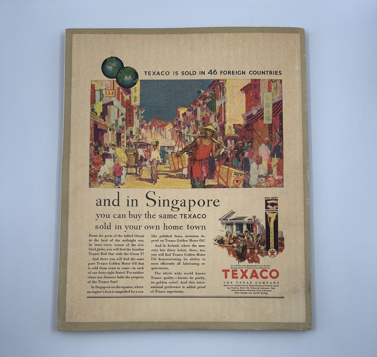 Vintage advertisement in the March 1930 Fortune Magazine for Texaco, depicting a vibrant street scene in Singapore to promote their fuel products worldwide.