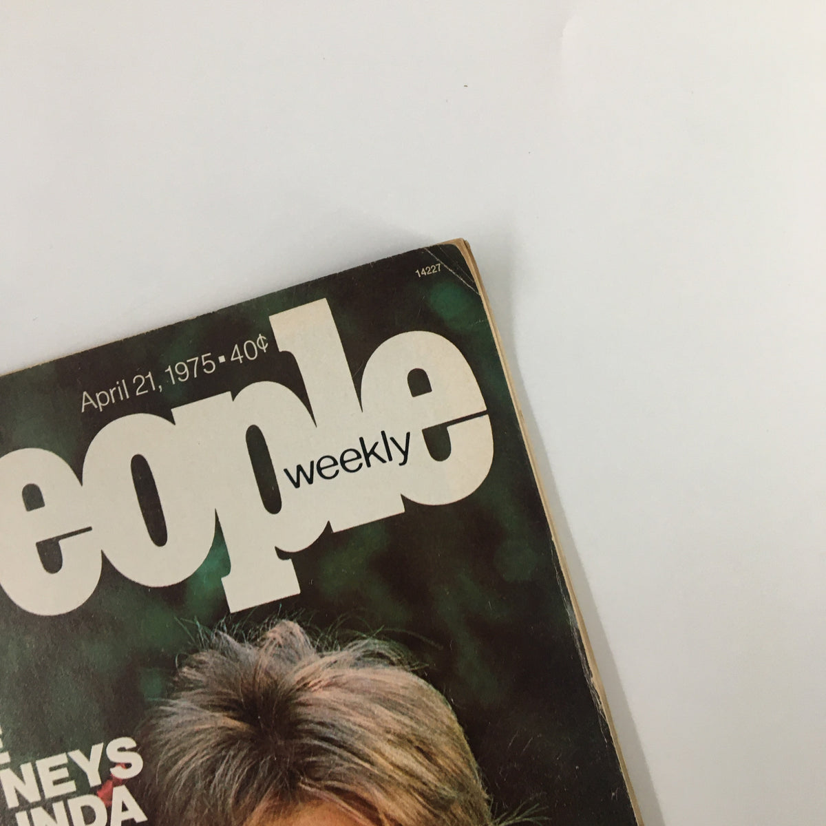 Close-up shot of the top corner of the People Weekly Magazine dated April 21, 1975. The title is partially visible along with the date and price, highlighting a vintage collectible featuring The McCartneys Paul and Linda.