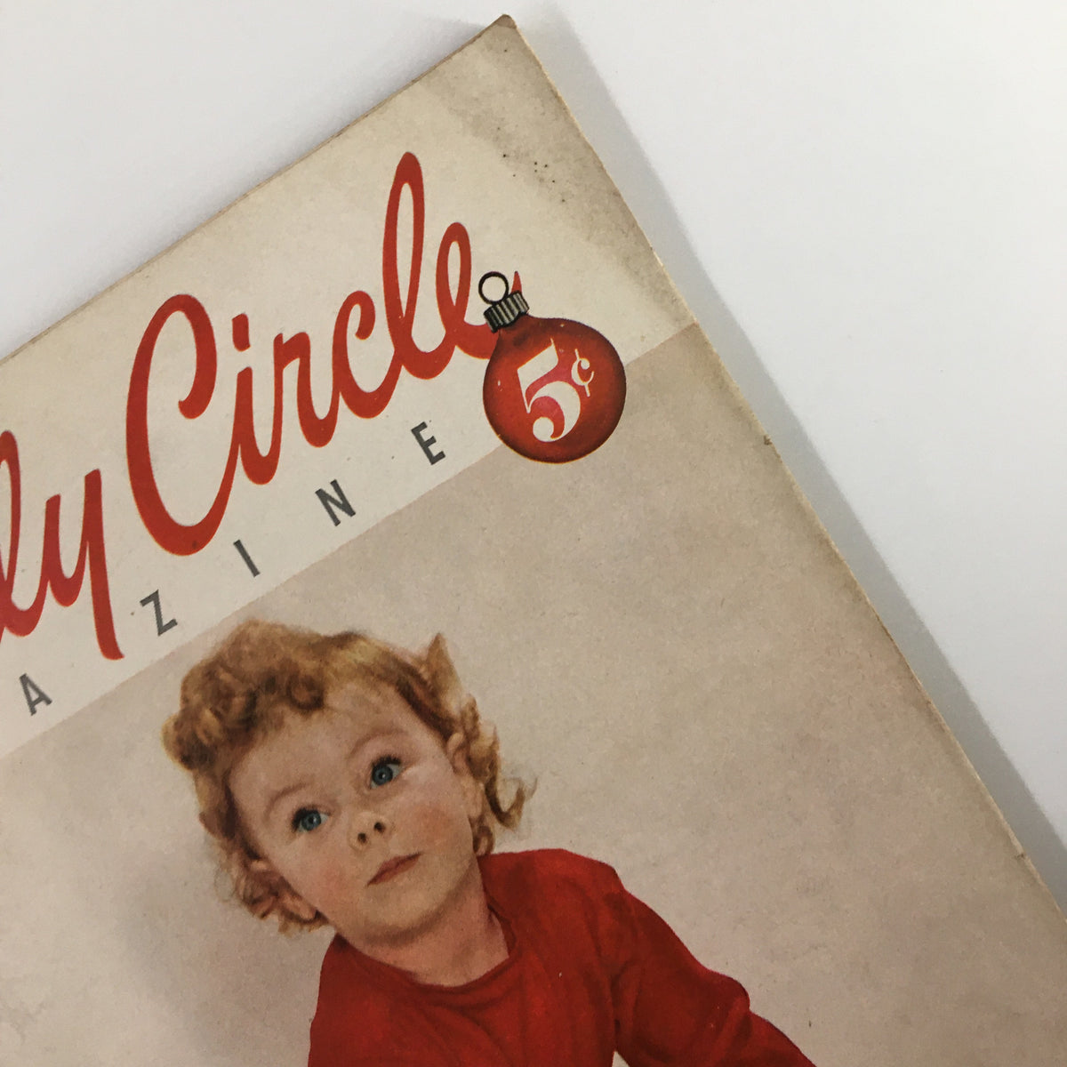 Zoomed in view of the Vintage Family Circle Magazine December 1953 cover emphasizing the magazine's price and child model.