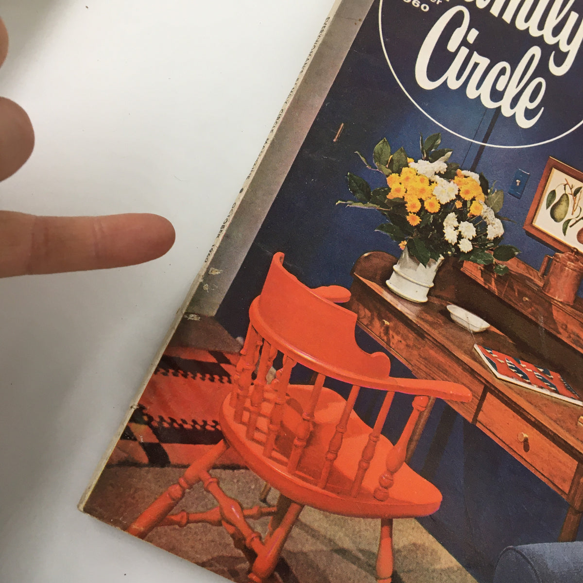 Cover of the VTG Family Circle Magazine from October 1960 featuring a vintage home setting with a red chair and floral arrangement, highlighting the theme of a covered-dish supper.