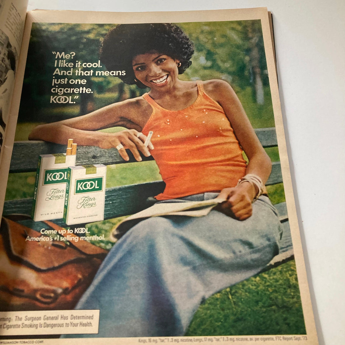Advertisement featuring a woman in an orange top holding a cigarette, for Kool cigarettes in the April 1974 Ebony Magazine.