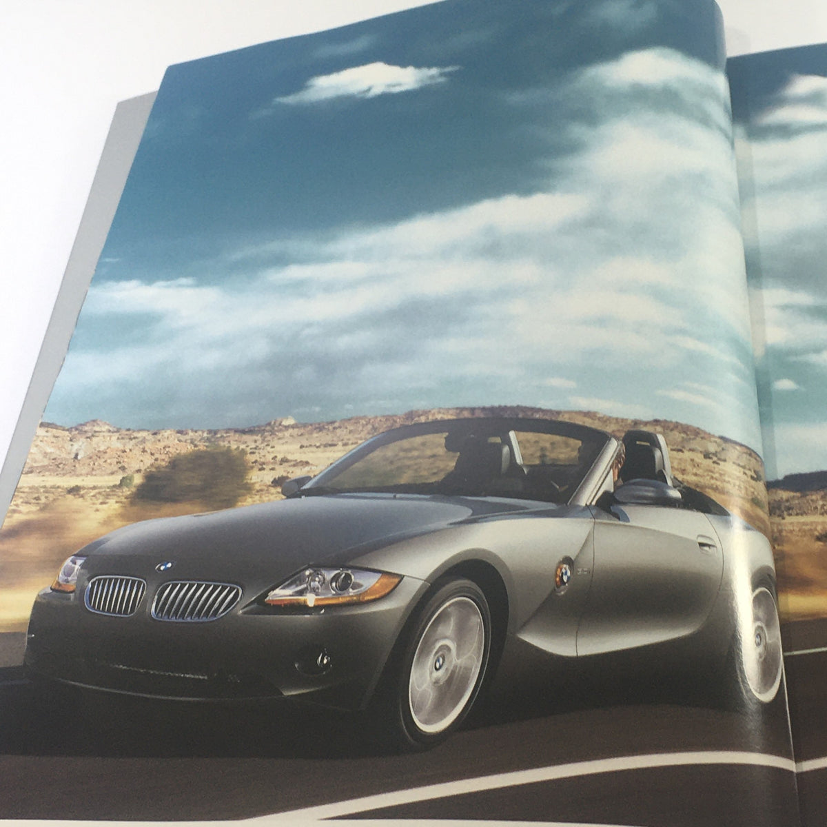 Interior page of the 2004 BMW Z4 Roadster 2.5i 3.0i Dealership Car Auto Brochure, displaying the BMW Z4 Roadster in a scenic outdoor setting.